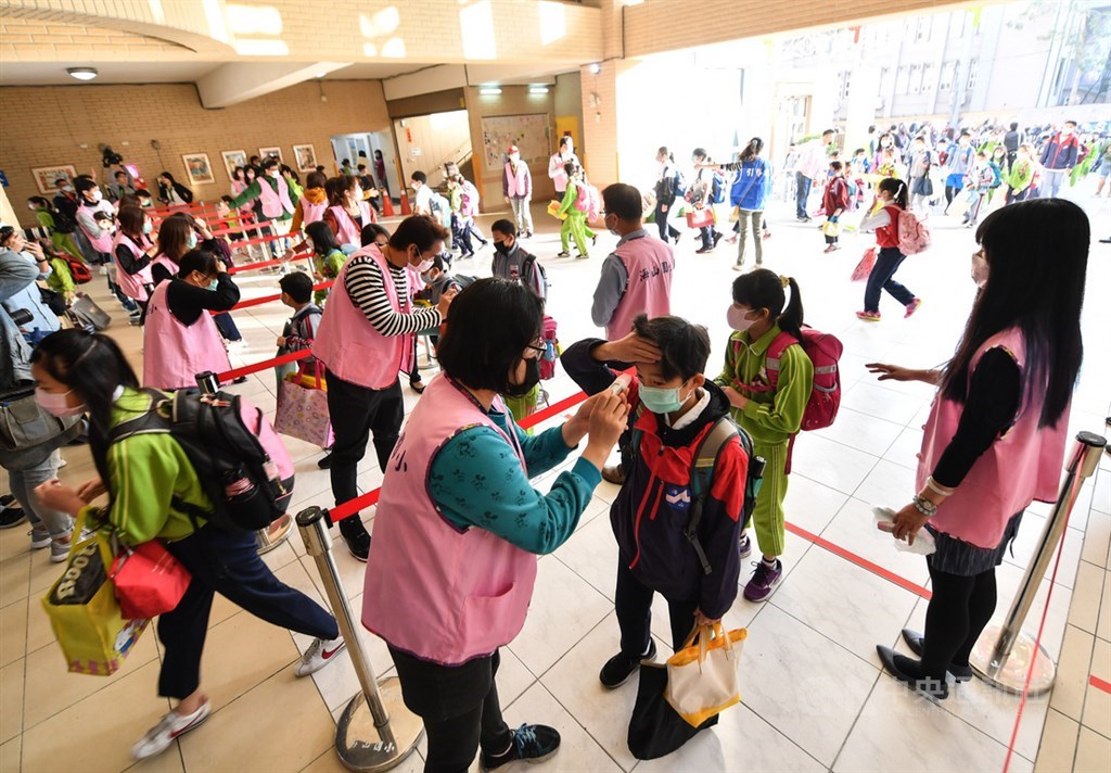 因應武漢肺炎疫情,新北市海山國小25日開學首日,在校門口規劃多條量測體溫路線,學童逐一測量額溫後才能進入校園。中央社記者林俊耀攝 109年2月25日