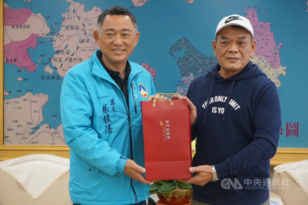 導演唐振瑜(右)26日拜會金門縣長楊鎮浯(左);楊鎮浯肯定電影「落番」和「戰酒」對金門鄉親和鄉僑帶來的迴響,期許新作呈現金門島嶼生活面貌,並致贈唐振瑜金門高粱酒。中央社記者黃慧敏攝 109年2月26日
