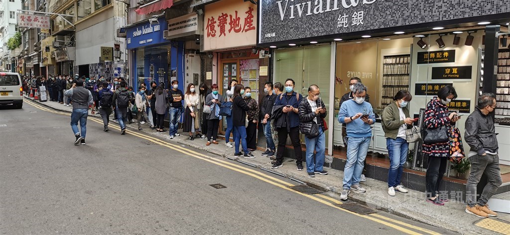 香港財政司司長陳茂波26日宣布,將會向每名18歲以上的香港永久居民發放港幣1萬元(約新台幣3.9萬元)。圖為數以百計市民7日在灣仔一家藥店外排隊買口罩。中央社記者張謙香港攝 109年2月7日