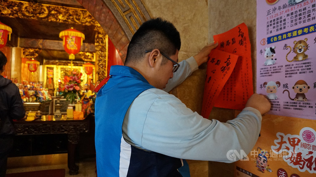 大甲鎮瀾宮27日宣布媽祖遶境進香活動延期,下午廟方人員在廟內牆上貼出告示。中央社記者趙麗妍攝 109年2月27日