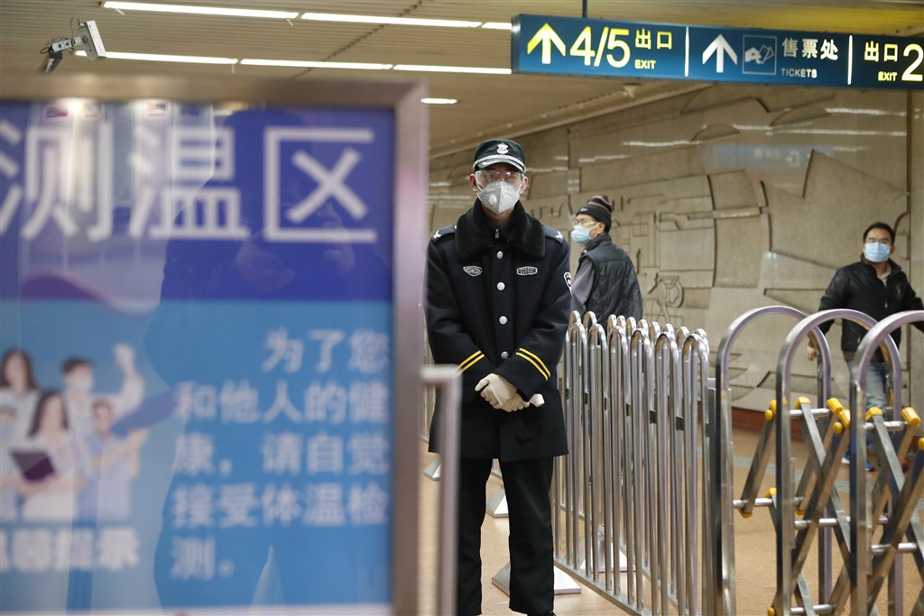 寧夏回族自治區中衛市發現一例境外輸入的武漢肺炎病例,這名患者從伊朗出發經莫斯科到中國,抵達寧夏前還曾在上海停留。圖為工作人員在上海火車站準備為民眾測量體溫。(中新社提供)