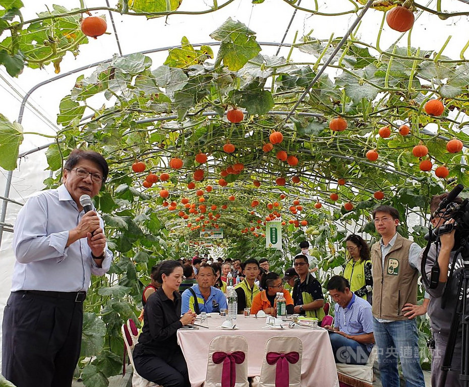 屏東縣長潘孟安(左)向中央爭取前瞻計畫興建「屏東縣熱帶農業特色產業園區」獲核定補助,園區裡的農業物產館27日動土,潘孟安會後在熱帶農業博覽會的瓜棚裡舉辦春酒慰勞工作人員。中央社記者郭芷瑄攝 109年2月27日