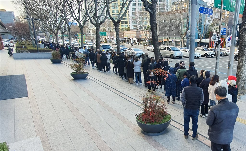 韓國疾病管理本部28日說,韓國通報新增256起武漢肺炎確診病例,累計共2022例。圖為27日大邱民眾排隊購買口罩。(韓聯社提供)