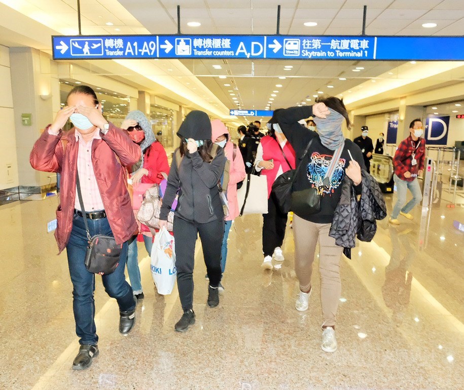 11名台灣旅客前往以色列,卻不巧與卻診武漢肺炎者同機而遭遣返,2日晚間返抵國門,戴著口罩的旅客一走出機艙口,紛紛以雙手緊拉著圍巾或帽沿,不希望被認出,沿途更是低著頭不發一語。中央社記者吳睿騏桃園機場攝 109年3月2日
