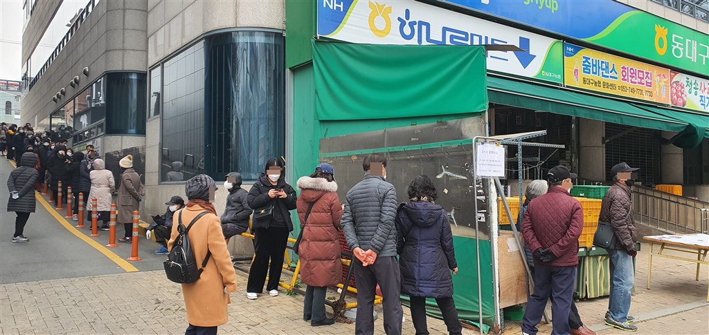 韓國8日上午通報新增93起武漢肺炎確診病例,目前韓國境內累積確診達7134例。圖為韓國民眾排隊買口罩。(韓聯社提供)