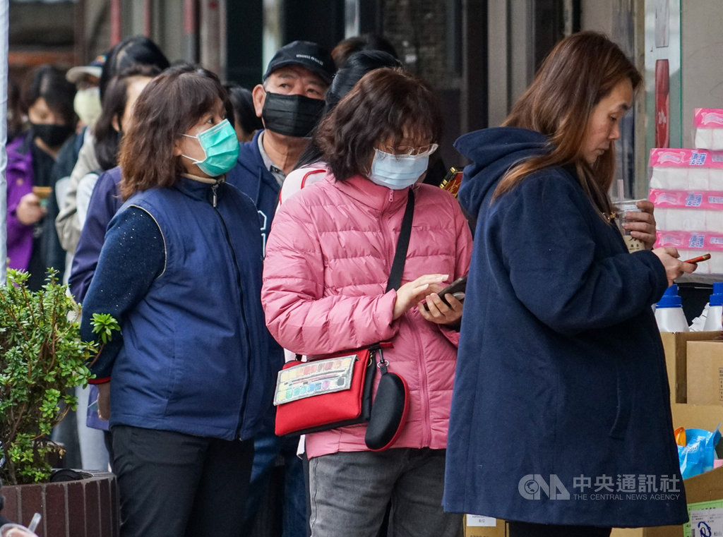 口罩實名制2.0將上路,12日起開放民眾網路預購成人口罩,但不受身分證字號單雙號分流限制,盼改善口罩分布不均,上班族沒時間排隊等問題。11日下午一間藥局外民眾大排長龍等候購買口罩。中央社記者裴禛攝 109年3月11日