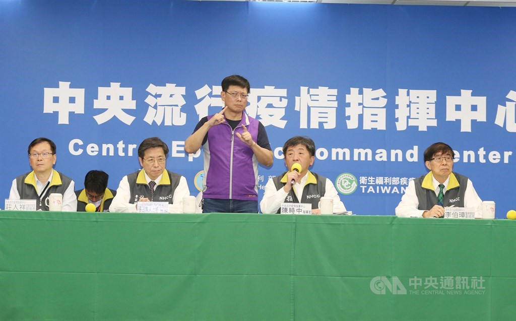 疫情指揮中心記者會上即席翻譯的手譯員未配戴口罩,引起民眾關心,手譯員李振輝(右3)表示,不戴口罩是避免遮住表情影響翻譯內容。(中央社檔案照片)