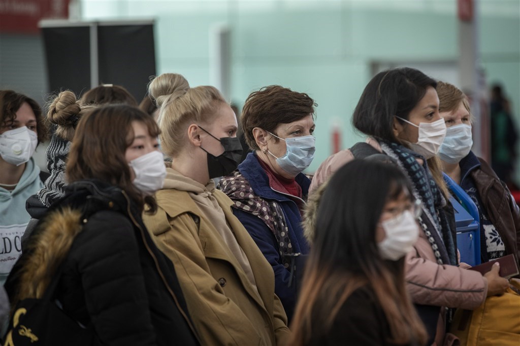 武漢肺炎延燒,已經造成全球近25萬人確診,1萬多人死亡。圖為西班牙巴塞隆納機場旅客戴著口罩。(美聯社)