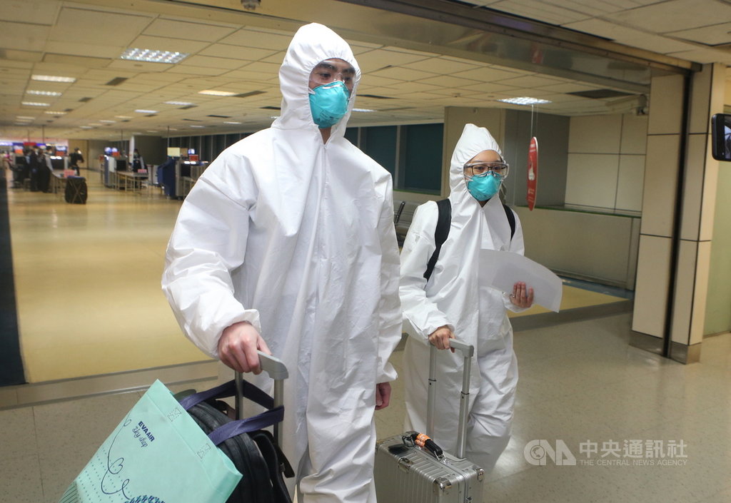 受到武漢肺炎疫情影響,22日桃園機場旅客人龍中不時可見戴著防護面具、穿著隔離衣,高度防疫裝備入境。中央社記者邱俊欽桃園機場攝 109年3月22日