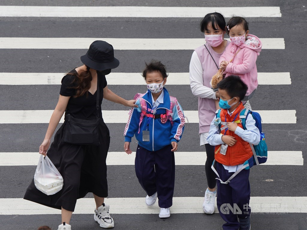 副總統陳建仁23日在臉書分析目前各國武漢肺炎疫情仍處上升階段,待緩和至少還需兩個月時間。圖為北市家長帶孩童外出,為他們戴好口罩。中央社記者徐肇昌攝 109年3月23日