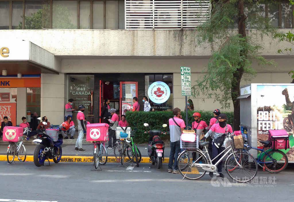 大馬尼拉地區封城超過一週,民眾不出門,外送業生意走俏,馬卡蒂市(Makati)一家提供外送的咖啡店前聚集不少外送員。中央社記者陳妍君馬尼拉攝 109年3月25日