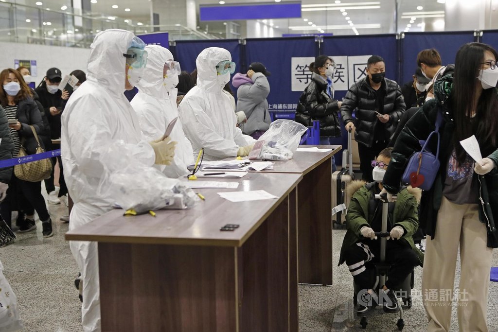 上海官方25日通報,24日新增19起境外移入的武漢肺炎確診病例,其中3人曾在桃園國際機場轉機,抵達上海浦東國際機場。圖為浦東機場工作人員身穿全套防護衣,引導入境旅客進行訊息核查。(中新社提供)中央社 109年3月25日