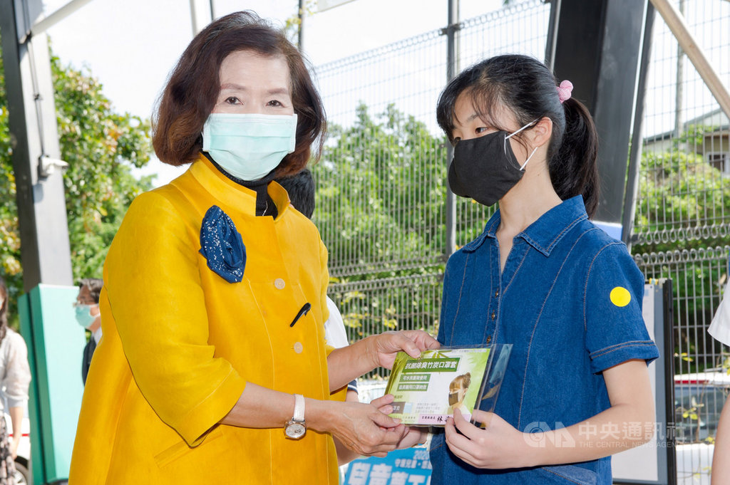 武漢肺炎疫情持續延燒,宜蘭縣政府今年準備4萬個「機能竹炭紗材質口罩套」當兒童節禮物,縣長林姿妙(左)26日到宜蘭市光復國小發放給學童。(宜蘭縣政府提供)中央社記者沈如峰宜蘭縣傳真 109年3月26日