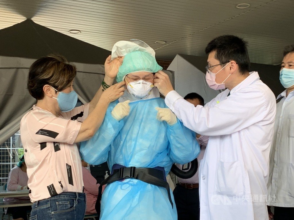 武漢肺炎疫情未歇,台積電慈善基金會陸續購買淨氣面罩及空氣濾淨主機、濾毒罐,捐給全台各地醫檢單位。董事長張淑芬(左)27日協助醫檢師配戴淨氣面罩,以行動為醫檢師加油打氣。中央社記者郭宣彣攝 109年3月27日