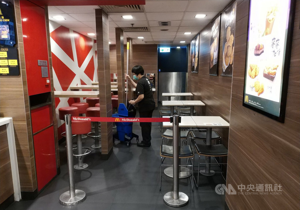 鑑於武漢肺炎近期出現第2波傳染高危期,有香港醫學專家27日建議政府禁止2至3人以上集會。香港麥當勞所有餐廳25日暫停堂食服務14天,圖為26日晚間,筲箕灣一家麥當勞將內用區分隔。(中通社提供)中央社 109年3月27日