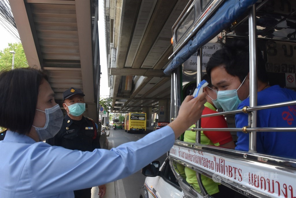 泰國皇家武裝部隊在進入曼谷主要道路設置檢查哨,隨機攔檢車輛。圖為醫護人員幫搭乘「雙條」的旅客量體溫。中央社記者呂欣憓曼谷攝 109年3月26日