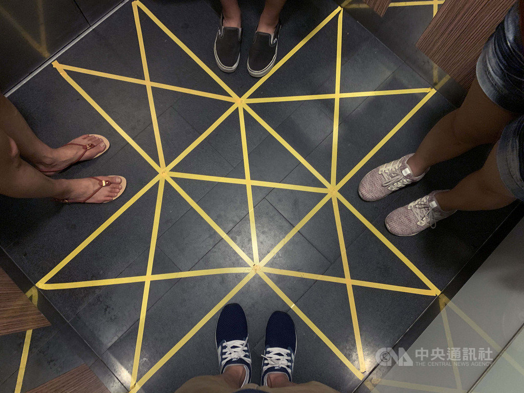 新加坡推動改變社交習慣的保持安全距離措施,違反規定是違法行為,新加坡商場或公寓電梯裡也劃設黑黃相間方格框,讓搭電梯民眾遵守規定。中央社記者黃自強新加坡攝 109年3月29日