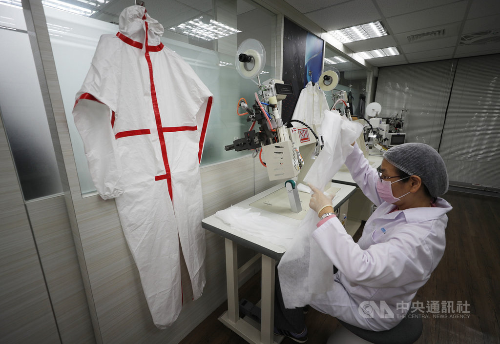 武漢肺炎疫情嚴峻,防疫資源更顯重要。圖為工作人員在隔離衣接縫處以熱氣縫合機密縫起來,隔絕外在污染。中央社記者裴禛攝 109年3月29日