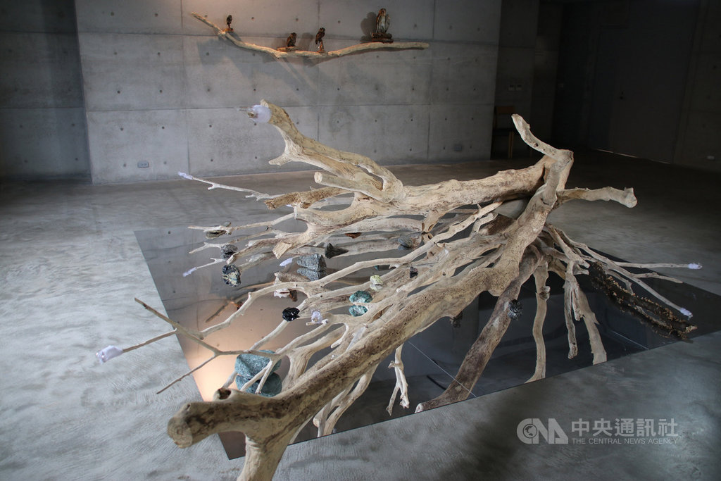 毓繡美術館推出「花園裡,植物記憶纏繞」展覽,呈現環境關愛及物種消逝的關懷,例如1樓展廳橫躺一棵枯樹,周圍擺置真菌、礦石、泥土、實驗室玻璃器皿,道出消逝、生死、治癒、循環等意象。中央社記者蕭博陽南投縣攝 109年3月29日