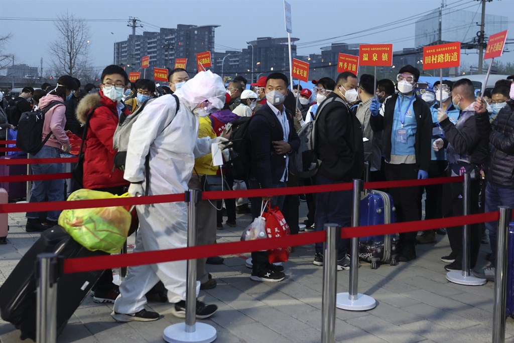 湖北省解封後,滯留當地的北京市民在官方以專列「點對點」運送下,有序分批回到北京並進行14天居家隔離。圖為2020年3月25日海淀區級集中分流點,在核對人員身分後由各街道統一送回住所。(中新社提供)中央社 109年3月29日