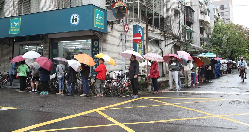 疫情指揮中心29日表示,防疫下一步考慮對沒有維持社交距離者開罰。圖為藥局外排隊等候購買口罩民眾。(中央社檔案照片)