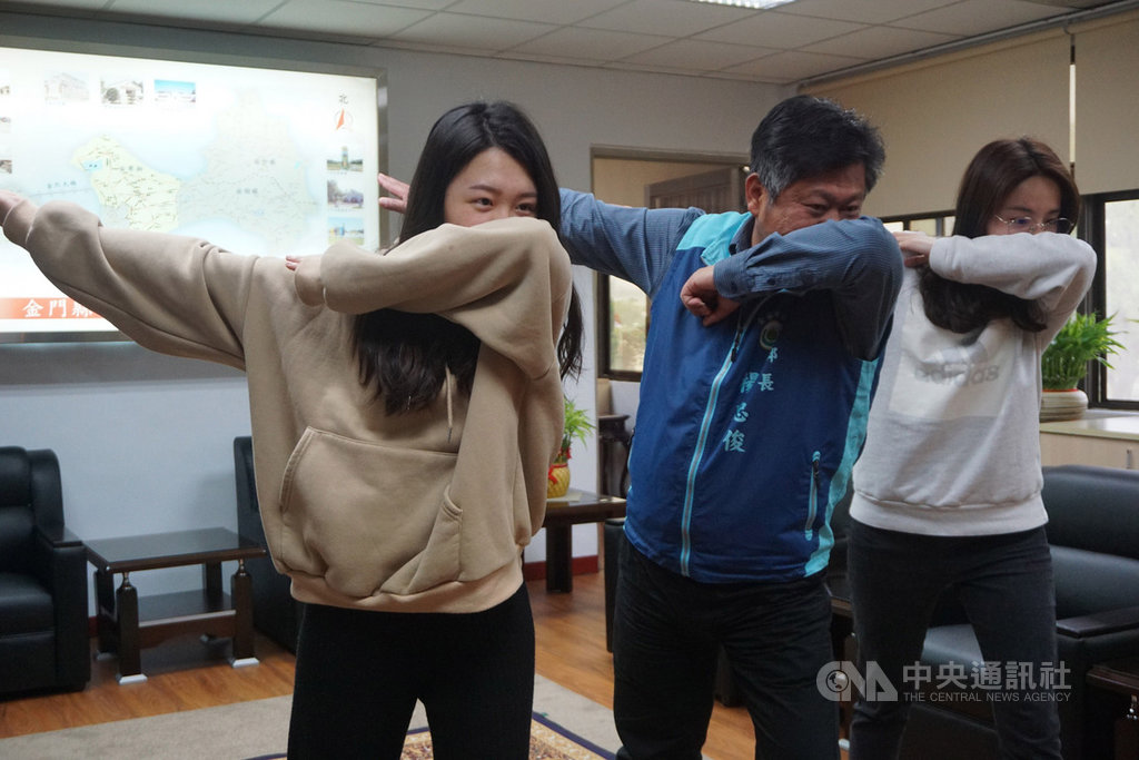 金門縣金寧鄉公所呼應衛生福利部疾病管制署咳嗽打噴嚏標準姿勢,結合冰桶挑戰模式,在臉書發起防範武漢肺炎「防疫宣傳接力活動」,鄉長楊忠俊(中)30日帶頭示範。中央社記者黃慧敏攝 109年3月30日