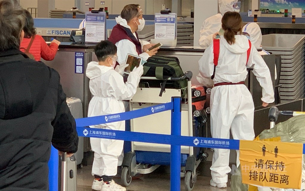 第2班湖北類包機30日晚間起飛,200多名乘客下午已辦理登機。圖為穿著自備防護衣的一家人。中央社記者沈朋達上海攝 109年3月30日