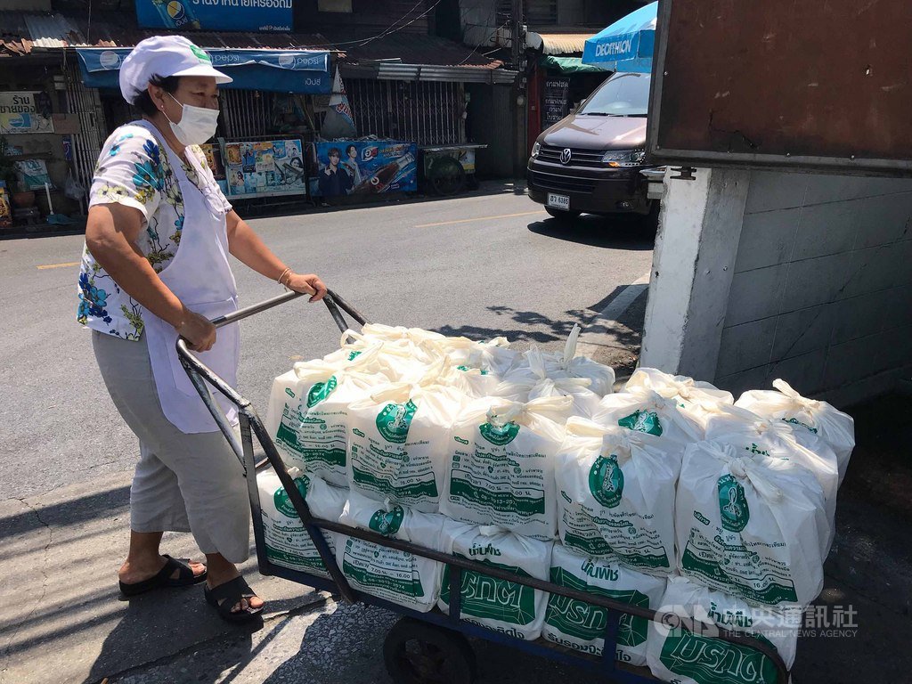 泰國疫情蔓延,為感謝醫護人員辛勞,忠姐燒肉店每天做上千個免費便當送給醫院,圖為老闆娘忠齋把便當推到貨車旁,準備送到醫院。中央社記者呂欣憓曼谷攝 109年3月31日
