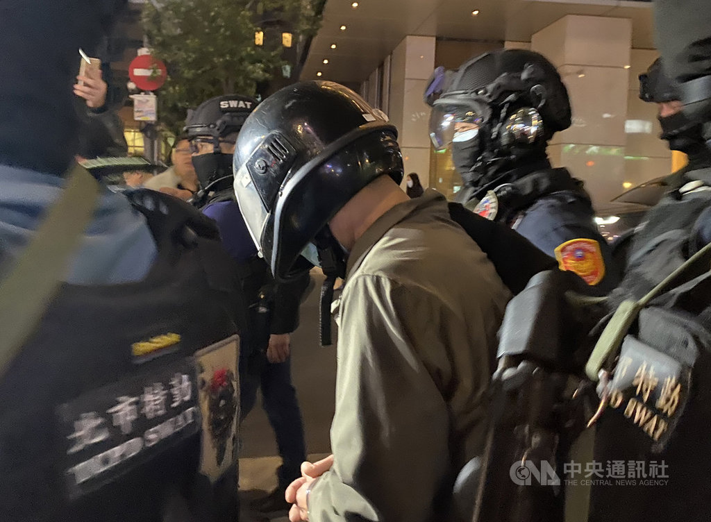54歲陳姓男子(中)因缺錢花用,30日上午持M4改造長槍行搶台北市板信商業銀行大直分行,他8年前也曾持刀搶劫彩券行;警方31日下午在桃園逮人,晚間7時帶回警局偵辦。中央社記者黃麗芸攝 109年3月31日