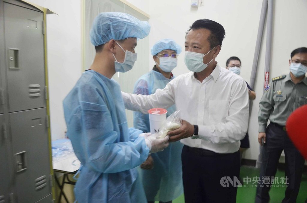 嘉義縣長翁章梁(前右)31日到嘉義縣朴子市口罩工廠,慰勞支援口罩生產的國軍弟兄,送上飲料與包子,感謝他們的付出。中央社記者蔡智明攝 109年3月31日