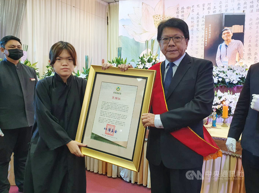 屏東作家郭漢辰25日因病過世,1日舉行告別式。屏東縣長潘孟安(右)前往弔唁,並代表屏東縣政府頒發褒揚狀,表彰他對在地文化的貢獻。褒揚狀由郭漢辰的女兒代表接受。中央社記者郭芷瑄攝 109年4月1日