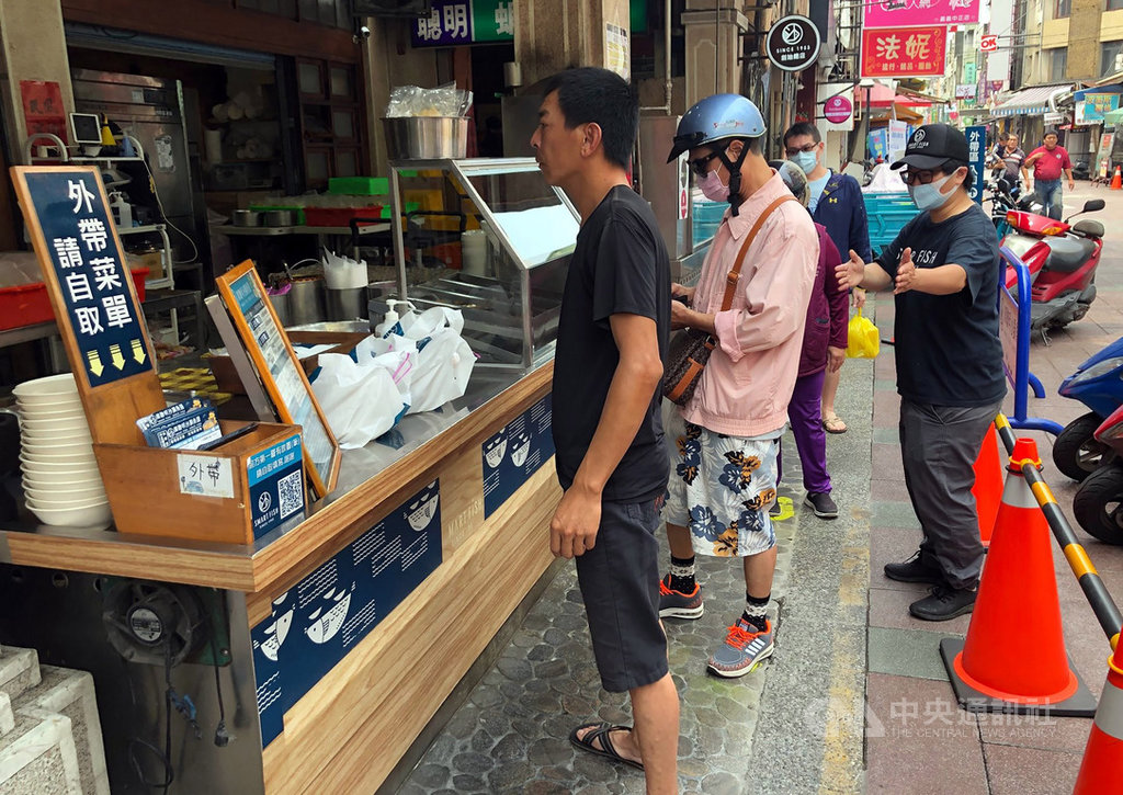中央流行疫情指揮中心宣布防疫社交距離,嘉義知名沙鍋魚頭店在外帶區上午就請員工在店門口外帶區以油漆每隔1公尺噴1個腳印,讓客人按照腳印排隊。中央社記者黃國芳攝 109年4月1日