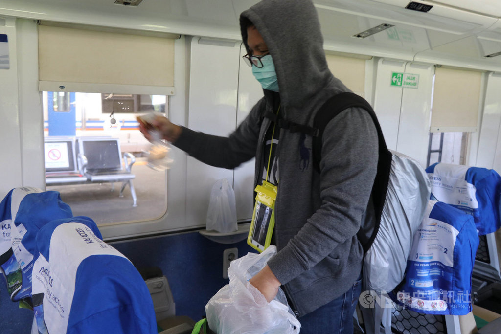 印尼國營鐵路公司1日起每天減少3分之2的班次,盼減少民眾返鄉,減緩武漢肺炎疫情擴散。圖為民眾3月31日搭乘火車時先將座位周圍消毒。中央社記者石秀娟雅加達攝 109年4月1日