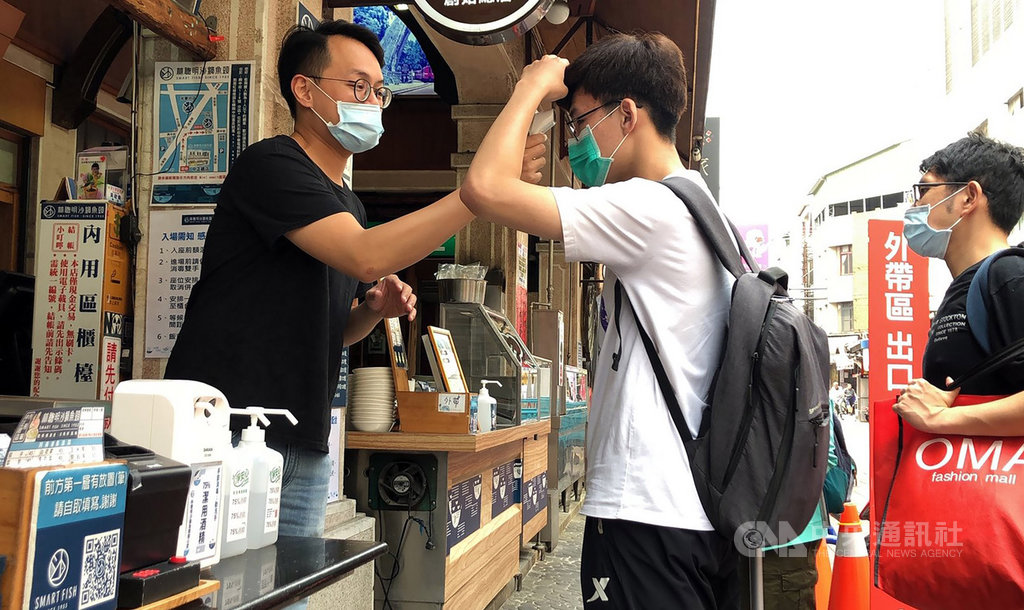 嘉義知名沙鍋魚頭店家配合政府防疫政策,上門消費者入場前皆需測量額溫、使用酒精消毒雙手,座位安排也取消併桌服務。中央社記者黃國芳攝 109年4月1日