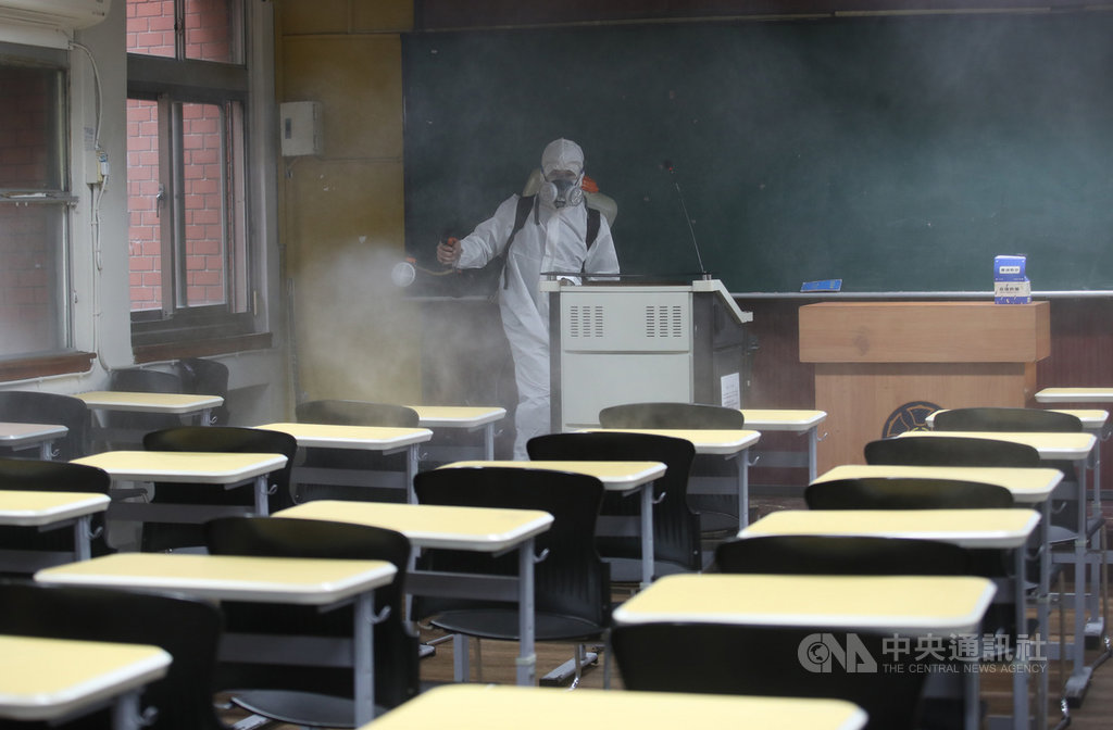 台灣師範大學一名學生確診2019冠狀病毒疾病(COVID-19,武漢肺炎),2日起清明連假,展開全校消毒工作,消毒人員穿著防護衣,在教室噴灑消毒水。中央社記者張新偉攝 109年4月2日
