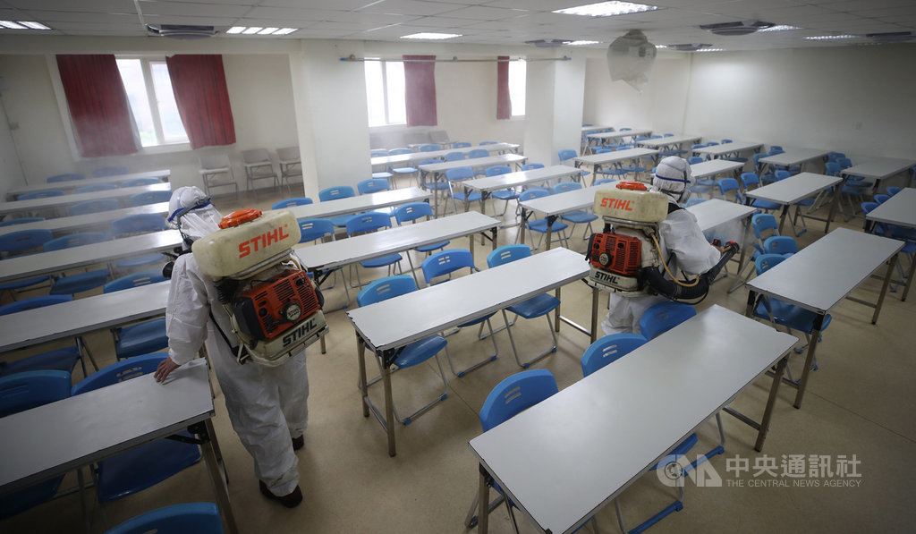 台灣師範大學一名學生確診2019冠狀病毒疾病(COVID-19,武漢肺炎),校方不敢大意,2日起清明連假進行全校消毒作業。消毒人員穿著防護衣,在校園周遭噴灑消毒水。中央社記者張新偉攝 109年4月2日