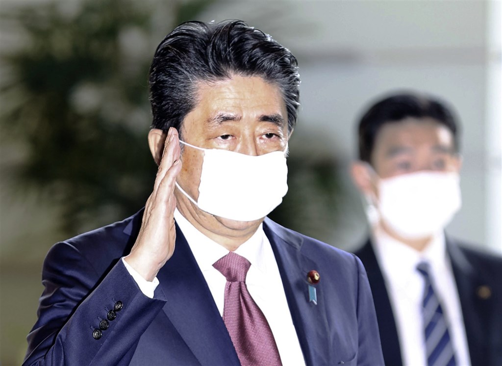 日本首相安倍晉三(前)宣布,將配送每戶2片「布口罩」解決防疫燃眉之急,結果遭民眾在社群媒體嘲笑揶揄。(共同社提供)