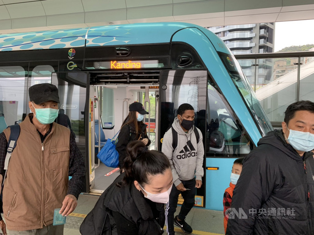 新北市全面實施搭乘大眾運輸工具配戴口罩,針對未依規定戴口罩且屢勸不聽者,最高將處新台幣1萬5000元罰鍰。民眾4日上午搭乘淡海輕軌戴上口罩配合防疫。中央社記者葉臻攝 109年4月4日