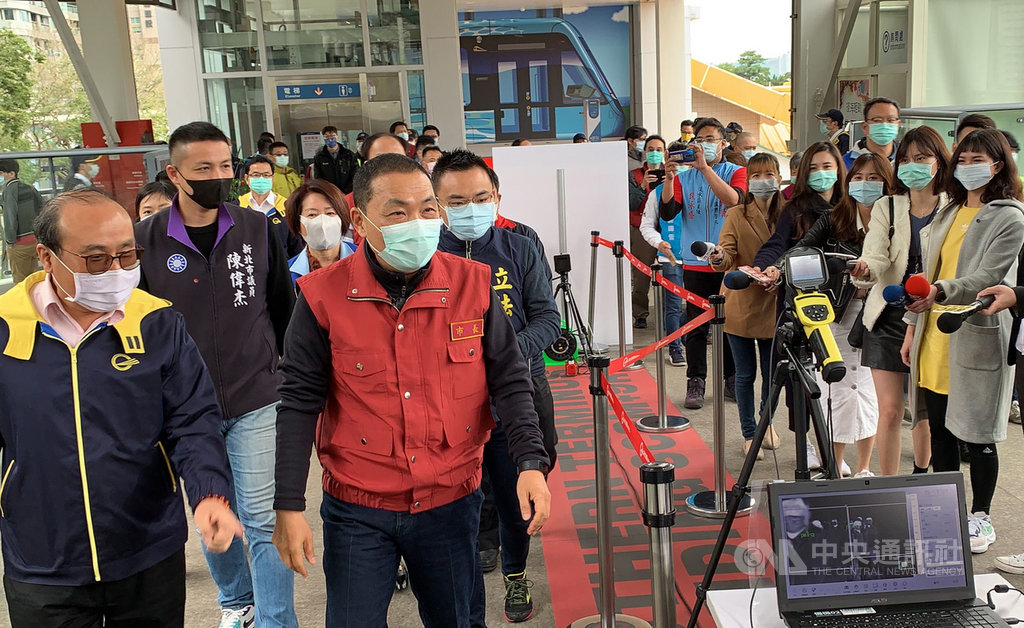 新北市長侯友宜(前左2)4日上午前往淡海輕軌紅樹林站視察防疫工作,聽取簡報後巡視淡海輕軌車廂,瞭解相關清潔消毒作業。中央社記者葉臻攝 109年4月4日