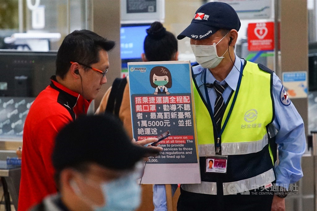 1日起搭乘大眾運輸工具應戴口罩,勸導不聽最重罰新台幣1萬5000元。台北捷運站務人員4日持看板勸導未戴口罩的民眾,希望民眾配合政策規定加強防疫。中央社記者王騰毅攝 109年4月4日
