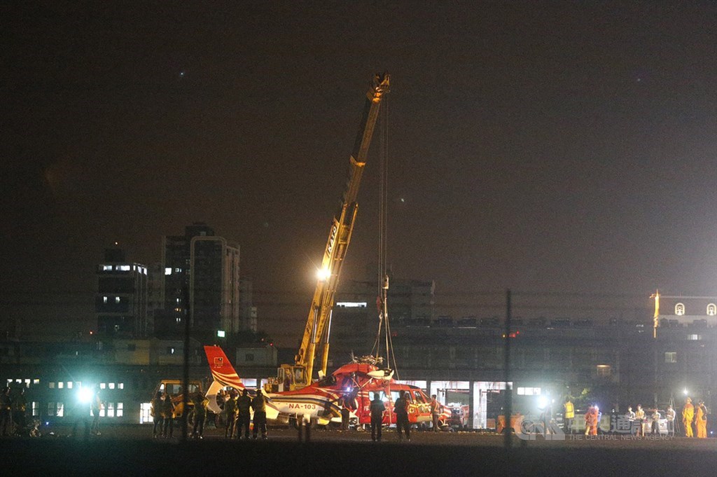 高雄小港機場7日下午發生空勤直升機落地翻覆事件,晚間出動吊車將側翻的機身吊起回正,並在拖離跑道後重新恢復班機起降。中央社記者董俊志高雄攝 109年4月7日