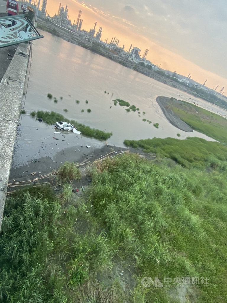 高雄林園警分局7日下午獲報在雙園大橋上,一輛自小客車行駛屏東東港往高雄林園方向,卻突然失控撞毀護欄後墜落河床,警消到場發現駕駛受困車內,全力搶救中。(警方提供)中央社記者程啟峰高雄傳真 109年4月7日