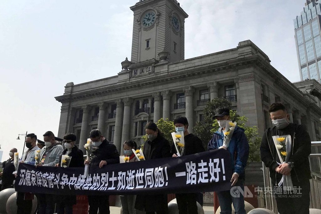 武漢市因未在第一時間隔離阻擊2019年新型冠狀病毒蔓延,封城76天付出慘痛代價。圖為2020年4月4日清明假期,民眾在武漢江漢關大樓前默哀。(中新社提供)中央社 109年4月8日