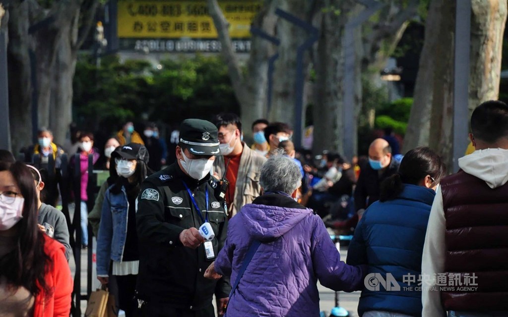 武漢8日解除封城,即便中國看似已恢復日常生活,但不少民眾仍擔心疫情,甚至懷疑官方數據。圖為清明連假上海靜安公園的人潮,保安仍為入園民眾量體溫。中央社記者沈朋達上海攝 109年4月8日