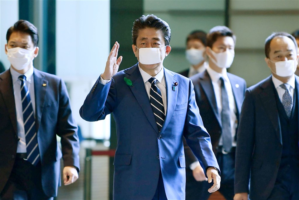 日本首相安倍晉三(中)戴著棉紗質口罩,被說很像是兒童版口罩,還有人批評一國首相戴著幾無過濾病毒功能的口罩是國家缺乏危機管理能力。(檔案照片/共同社提供)