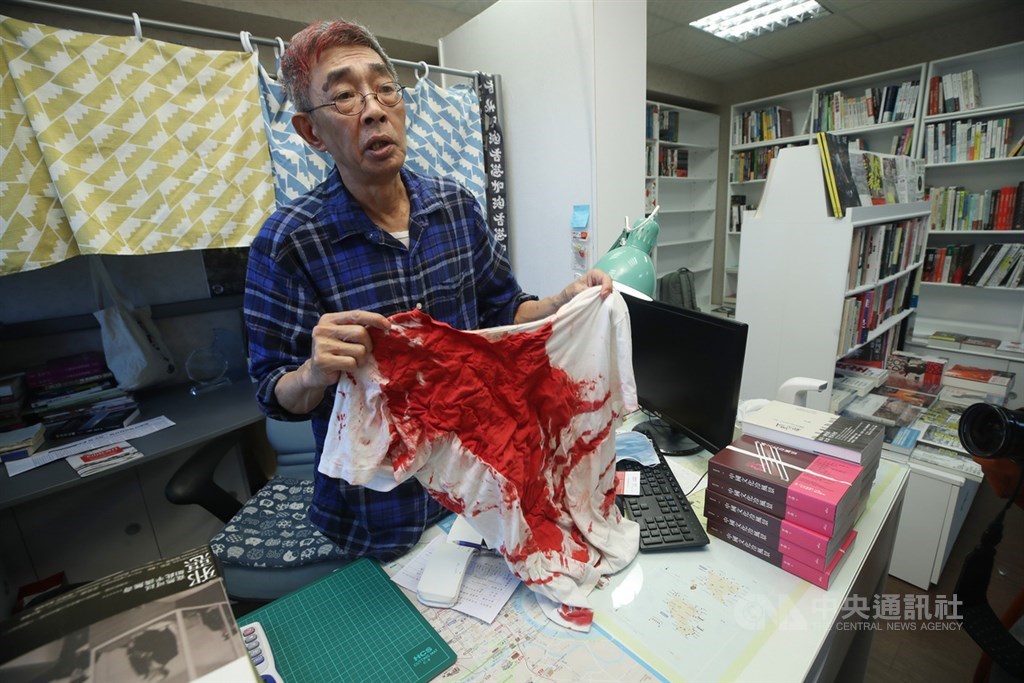 香港銅鑼灣書店前店長林榮基21日遭不明男子潑漆,造成林榮基頭部、衣褲都是紅漆污漬。圖為林榮基22日在書店受訪,展示衣服上的紅漆。中央社記者張新偉攝 109年4月22日