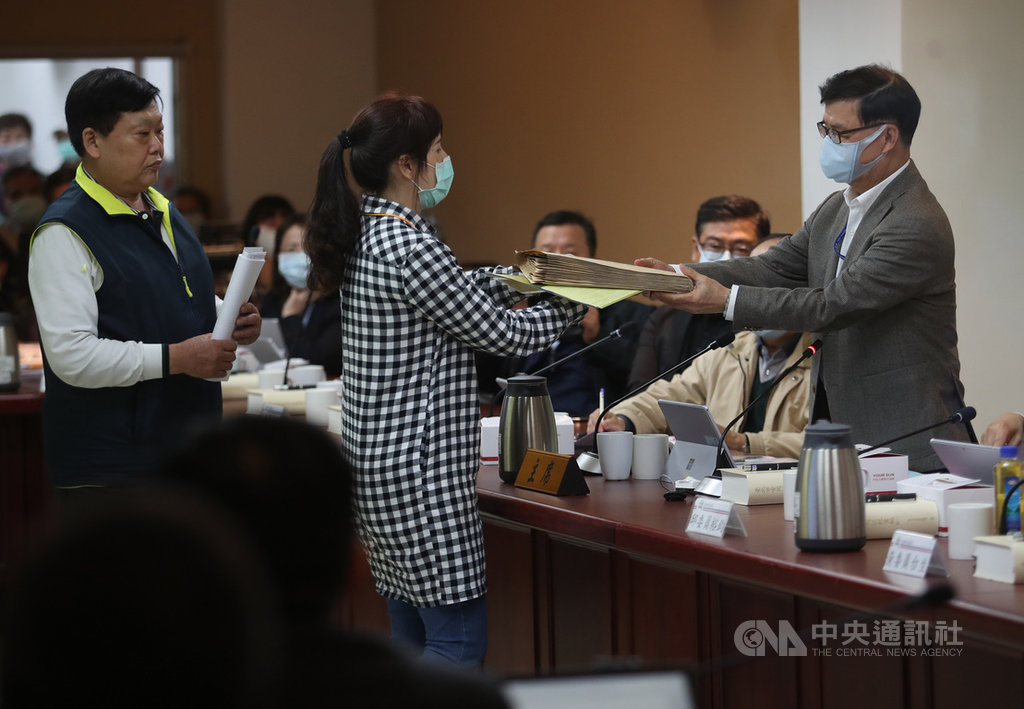台北市都委會23日再度審議社子島開發案,反對區段徵收的社子島自救會要求應讓居民在審議會發言,社子島自救會發言人李華萍(中)進入審議會遞交陳情書給主任委員彭振聲(右)。中央社記者張新偉攝 109年4月23日