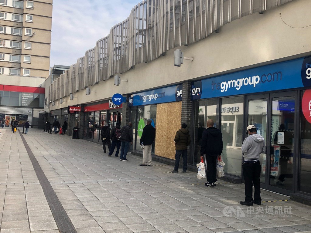 英國在3月23日宣布禁足令,不過民眾依舊可以出門購物、運動,可說是實施「軟隔離」。圖為英國實施保持社交距離政策,超市外以膠帶標示距離。中央社記者戴雅真倫敦攝 109年4月14日