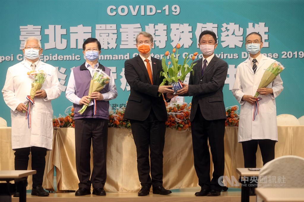 荷蘭貿易暨投資辦事處代表紀維德(Guy Wittich)(中)27日贈送鬱金香給台北市立聯合醫院醫護人員,表達對台灣第一線醫護人員的謝意,由台北市政府發言人周台竹(右2)代表接受。中央社記者鄭傑文攝 109年4月27日
