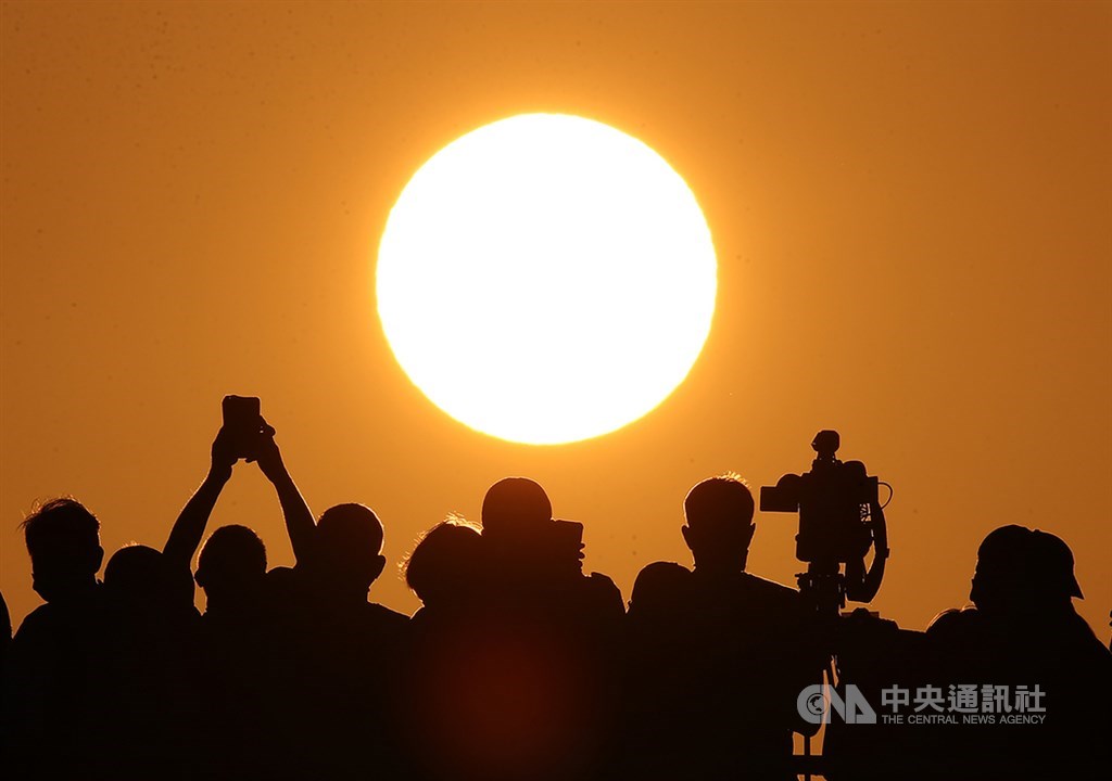 台北市4月30日到5月4日傍晚在無雲遮擋下出現懸日美景,不少「攝手」卡位搶拍。中央社記者張新偉攝 109年4月29日